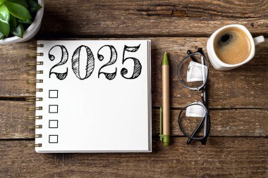 Yeni yıl kararları 2025 masada. Not defteri ve kahve fincanı olan 2025 karar listesi. Hedefler, çözümler, plan, eylem, kontrol listesi konsepti. Yeni Yıl 2025 şablonu, kopyalama alanı