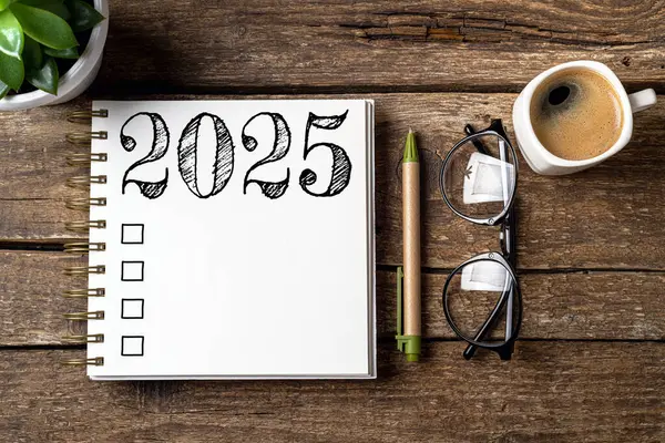 Yeni yıl kararları 2025 masada. Not defteri ve kahve fincanı olan 2025 karar listesi. Hedefler, çözümler, plan, eylem, kontrol listesi konsepti. Yeni Yıl 2025 şablonu, kopyalama alanı