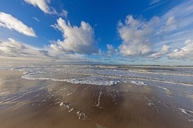 Danimarka 'da Vejers yakınlarındaki Kuzey Denizi sahilinin yansımaları ve etkileyici bulut oluşumlarıyla