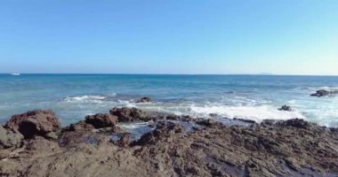 Gündüz vakti Lanzarote kanarya adasındaki Los Ajaches Ulusal Parkı 'ndaki kayalık sahil şeridinde video yansıması.