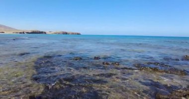 Gündüz vakti Lanzarote kanarya adasındaki Los Ajaches Ulusal Parkı 'ndaki kayalık sahil şeridinde video yansıması.