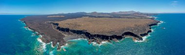 Lanzarote 'de El Golfo yakınlarında gündüz güneşinde Playa del Paso ile birlikte volkanik sahilin insansız hava aracı panoraması.