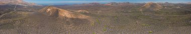Lanzarote 'deki çorak volkanik Timanfaya Ulusal Parkı üzerindeki panoramik dron görüntüsü