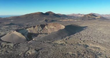 Lanzarote 'deki kısır volkanik Timanfaya Ulusal Parkı' nda güneş doğarken insansız hava aracı videosu.