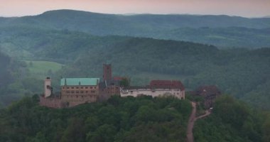 Sabahleyin Eisenach üzerinde Wartburg kalesine doğru sisli bir havada insansız hava aracı uçuşu.