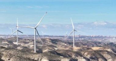 İHA videosu İspanya 'daki tepelik bir çöl arazisindeki rüzgar çiftliği üzerinde.