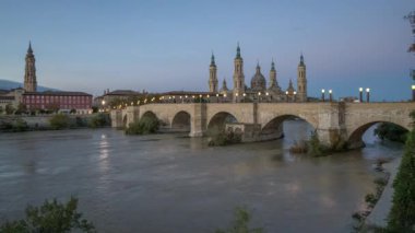 Gece gündüz Zaragoza Katedrali 'nin gün doğumunda Ebro nehrinin üzerinde.