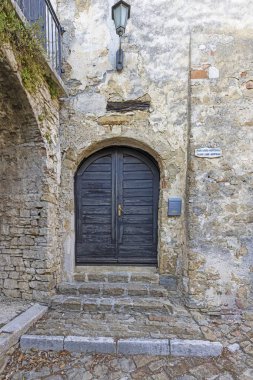 Gündüz vakti antika görünümlü bir binanın yeşil giriş kapısı görüntüsü.