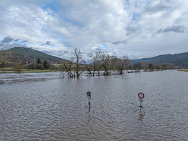 Gündüz vakti taşan ağaçlar ve trafik işaretleriyle dolu bir sel sırasında Alman Nehri 'nin insansız hava aracı görüntüsü.
