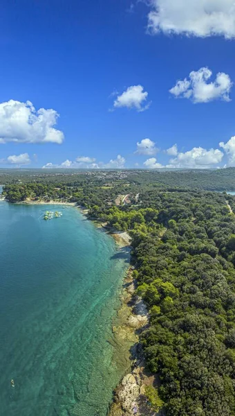 Vertical drone panorama over a stretch of coast near the town of Pula in Istria during the day