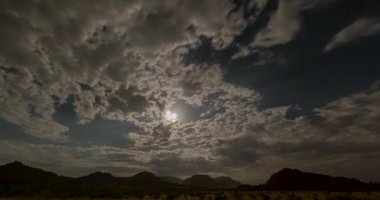 Gece gündüz Namibya 'nın üzerinde hızla hareket eden bulutlarla dolu bir gece filmi.