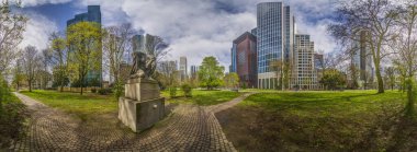 Gün boyunca açık bulutlu mavi gökyüzünün önündeki Frankfurt siluetinin panoramik resmi