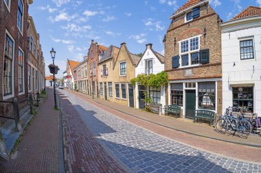 Gündüz vakti Rotterdam yakınlarındaki tarihi Hollanda kenti Brielle 'deki tipik bir kaldırımlı caddenin resmi