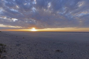 Hollanda 'da Ouddorp plajının üzerindeki panoramik resim yazın günbatımında