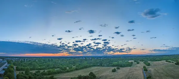 stock image An aerial view of a vast landscape with an abundance of lush trees and a cloud-filled sky