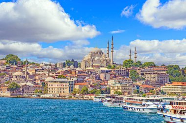 Sultanahmed Camii 'nin gündüz vakti hafif bulutlu bir gökyüzüne karşı sudan çekilmiş fotoğrafı.