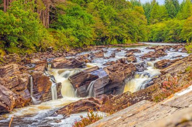 Gün ışığında uzun süre çekim yapılan kayalık bir bölgede çağlayan bir nehrin görüntüsü