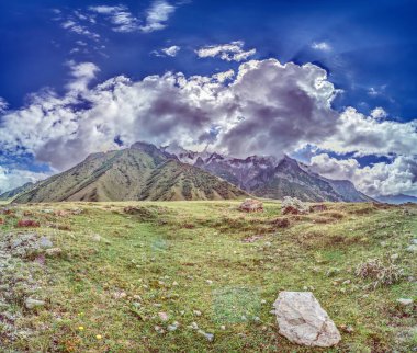 Scenic view of the Cross Pass in Georgia, showcasing lush green mountains and a winding valley during daytime clipart