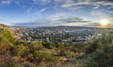 Gürcistan 'ın Tiflis kentindeki panoramik gündüz manzarası, gün boyunca renkli çatılar ve simgelerle