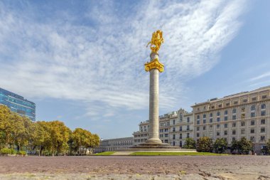 Yazın güneşli bir günde Gürcistan 'ın Tiflis kentindeki Liberty Meydanı' nda altın bir heykel.