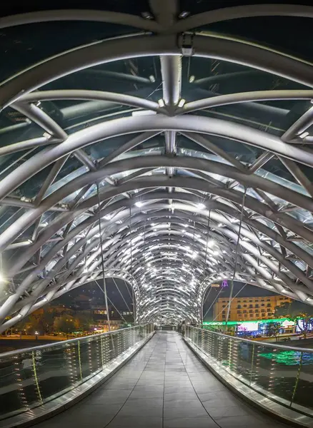 Gürcistan 'ın Tiflis kentindeki barış köprüsü, Kura Nehri üzerinde gece aydınlandı, yazın yapay ışıkla yakalandı.