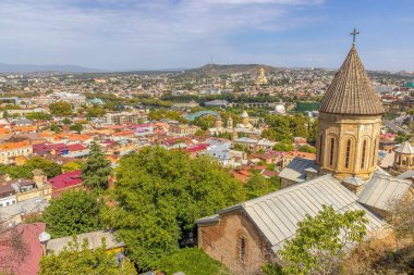 Gürcistan 'ın Tiflis kentindeki panoramik gündüz manzarası, gün boyunca renkli çatılar ve simgelerle