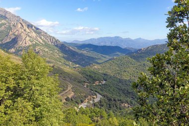 Korsika 'nın doğu kıyı şeridinin panoramik görüntüsü gün boyunca verimli yeşilliklerle dolu dağlık iç kesimlerden yakalandı.