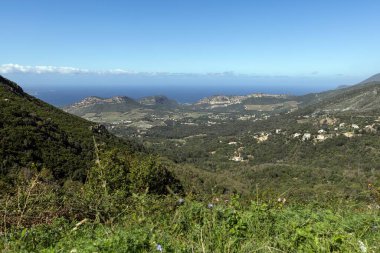 Korsika 'nın doğu kıyı şeridinin panoramik görüntüsü gün boyunca verimli yeşilliklerle dolu dağlık iç kesimlerden yakalandı.