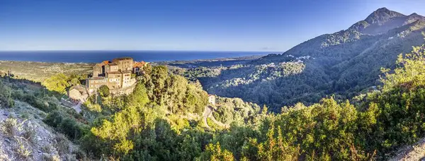 Geleneksel bir Korsika dağ köyünün panoramik manzarası. Gündüz vakti engin doğu kıyı şeridi.