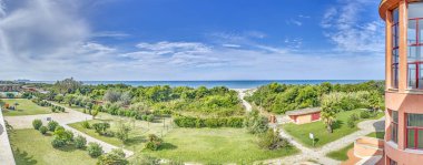 Yaz mevsiminde Livorno sahilinin panoramik manzarası. Gündüz vakti arka planda yeşillik ve deniz var.