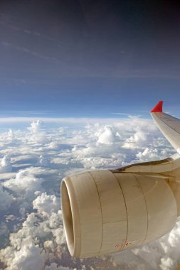 Stunning aerial view of clouds from airplane window showcasing a serene and breathtaking sky scenery during daytime clipart