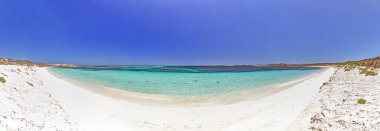 Turkuvaz suları ve Rottnest Adası 'ndaki kayalık kıyı şeridi ile gündüz vakti masmavi gökyüzünün altında