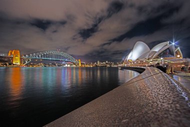 Sydney Harbour Bridge illuminated at night with reflections on calm water in 2015 clipart