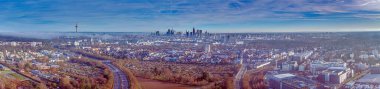 Frankfurt ufuk çizgisinin panoramik bir görüntüsü. Gündüz vakti sis ve yerleşim alanları ön planda.