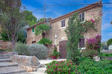 Gündüz vakti Mallorca 'da yemyeşil yemyeşil taştan bir ev