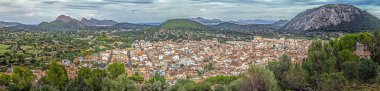 View over Pollenca from surrounding hills during daytime clipart