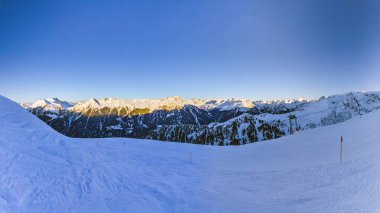 Panoramic view over snow covered ski slopes and mountains in Kleinwalsertal in winter clipart