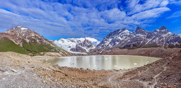 Gündüz vakti Patagonya 'da Cerro Torre' nin bereketli önplanı ve dramatik kar örtülü dağlarıyla panoramik görüntüsü