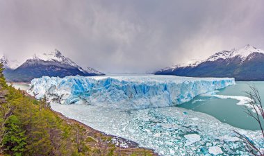 Perito Moreno Buzulu dramatik buzlu duvarı ve Patagonya 'daki karlı dağlarla gündüz vakti