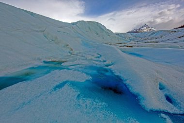 Gündüz vakti Patagonya 'daki Gri Buzul' un yüzeyinde canlı bir erimiş su gölü.