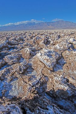 Gündüz vakti açık mavi gökyüzünün altında Şeytani Golf Sahasının engebeli tuz oluşumları