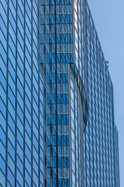 Gündüz vakti Frankfurt 'ta mavi gökyüzünü yansıtan modern cam cephe kapanıyor.