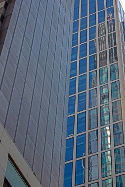 Close up of modern glass facade reflecting blue sky in Frankfurt in daylight clipart