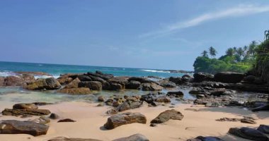 Sessiz Sahil Sri Lanka. Güçlü dalgalar ve açık gökyüzü altında sabah güneşi. Çok az insan görülebilir.