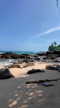 Sessiz Sahil Sri Lanka. Güçlü dalgalar ve açık gökyüzü altında sabah güneşi. Çok az insan görülebilir.