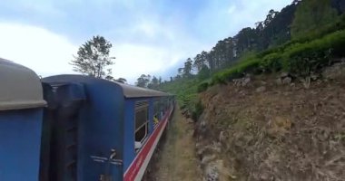 Sri Lanka 'dan geçen manzaralı trenin açık kapı manzarası Kandy ve Ella arasındaki yemyeşil tepeler.