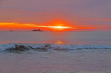 Ventura sahilinde güneş batıyor. Akşamları yumuşak dalgalar ve turuncu ışıltıyla.