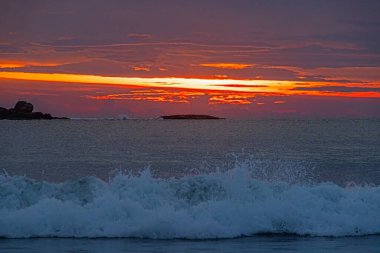 Ventura sahilinde güneş batıyor. Akşamları yumuşak dalgalar ve turuncu ışıltıyla.