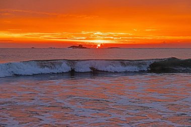 Ventura sahilinde güneş batıyor. Akşamları yumuşak dalgalar ve turuncu ışıltıyla.