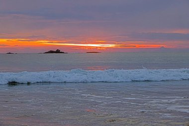 Ventura sahilinde güneş batıyor. Akşamları yumuşak dalgalar ve turuncu ışıltıyla.